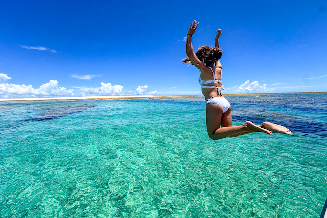 慶良間の透明度抜群の海に飛び込む写真
