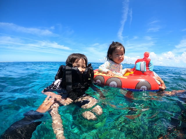 沖縄で子供と一緒に海で遊んでいる写真